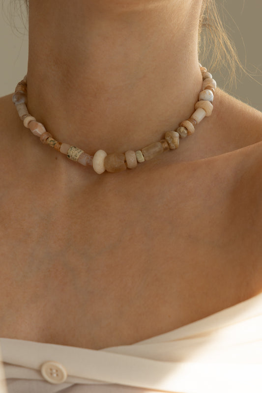 Close up of a female neck wearing an ancient quartz beaded necklace.
